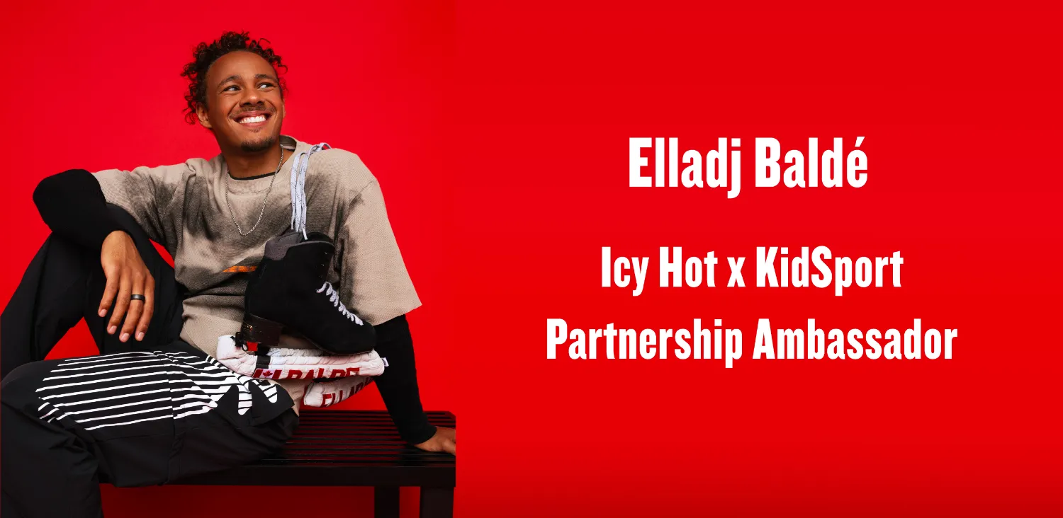 A man holds a football, and looks over his shoulder.